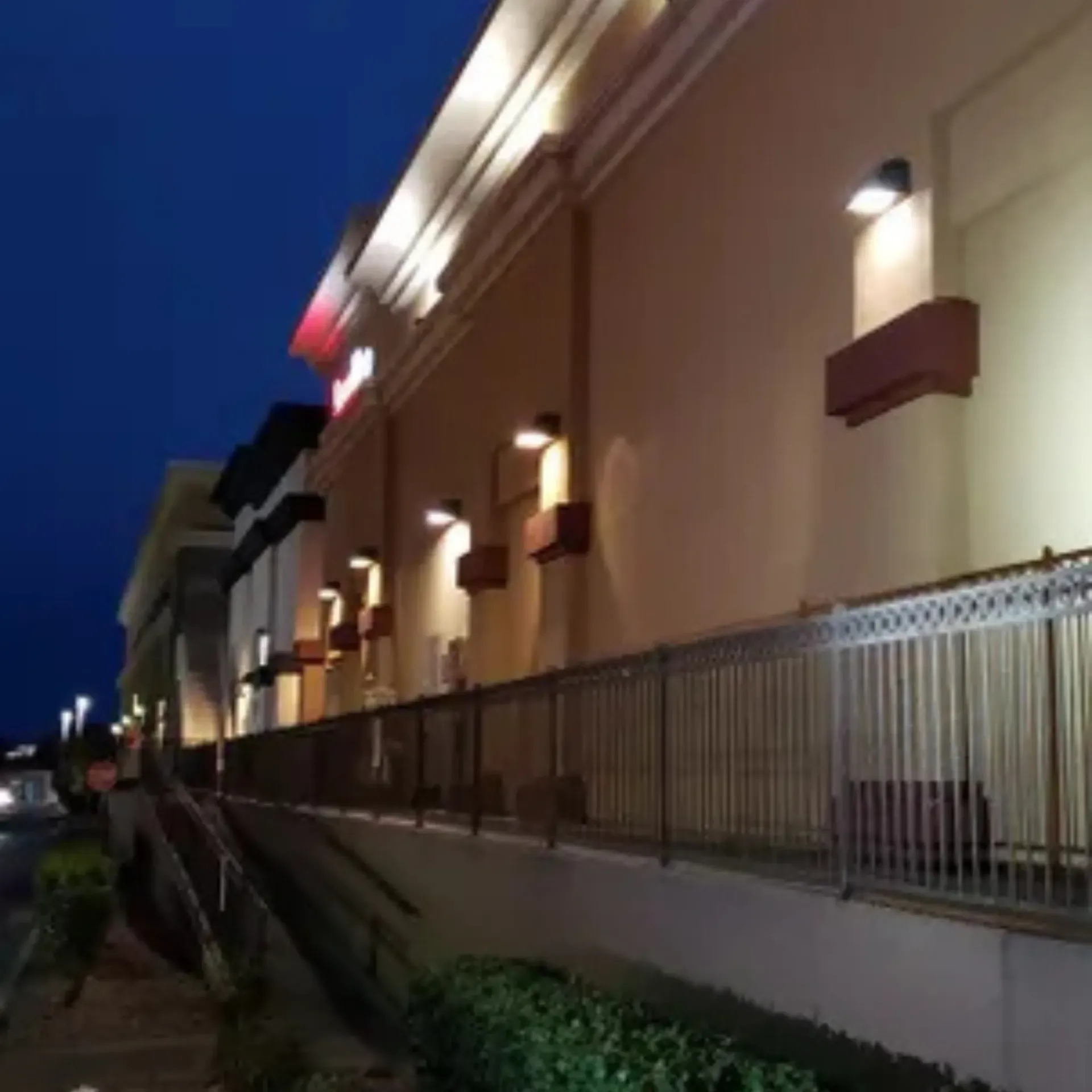 OE Services LLC - A building with a fence around it is lit up at night
