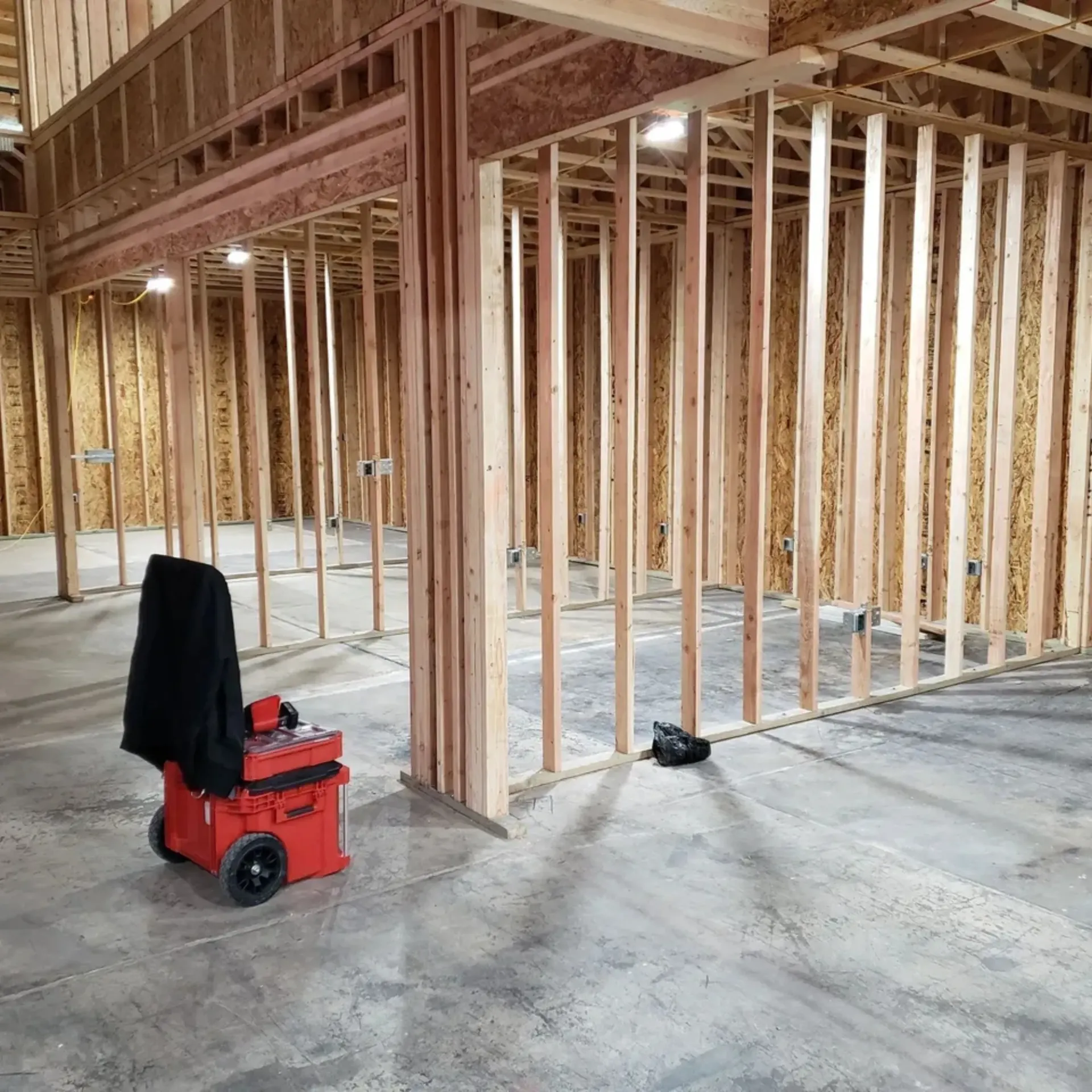 OE Services LLC - A red vacuum cleaner is sitting in the middle of a building under construction.