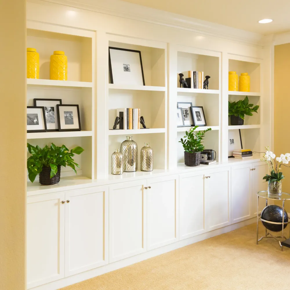 OE Services - A living room filled with white cabinets and shelves
