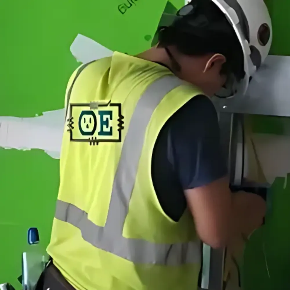 OE Services - A man wearing a yellow vest with oe on the back