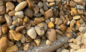Pile of smooth tan and gray pebbles filling the frame