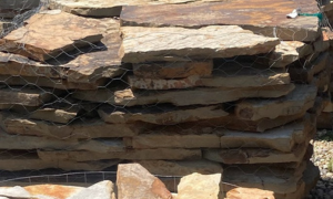 Stacked flat rocks behind wire mesh fencing in an outdoor area