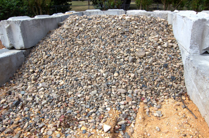 Pile of gravel between concrete retaining blocks outdoors