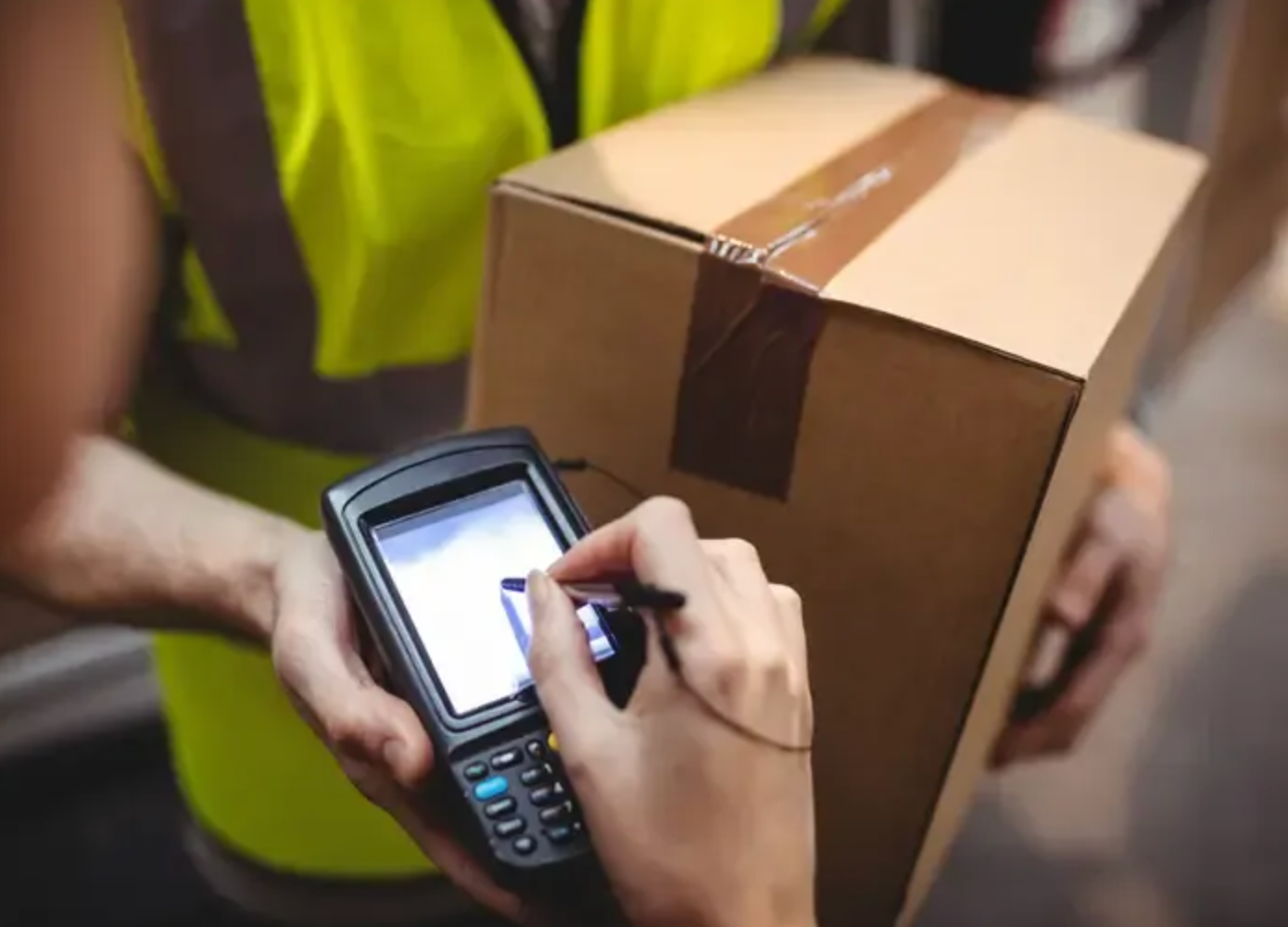 Delivery Worker Scanning a Cardboard Package With a Handheld Device — Access Couriers in Taree, NSW