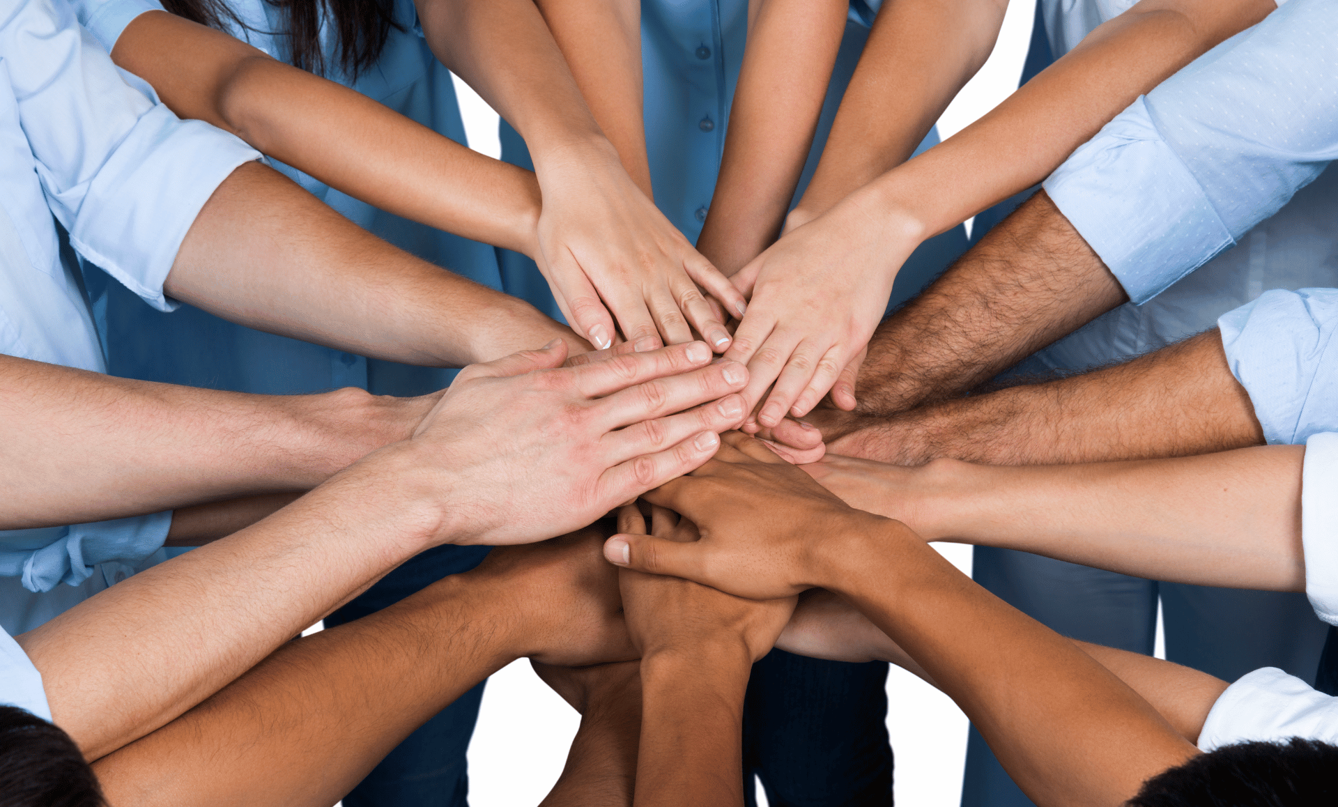 Hands of diverse people stacked together in a show of teamwork.