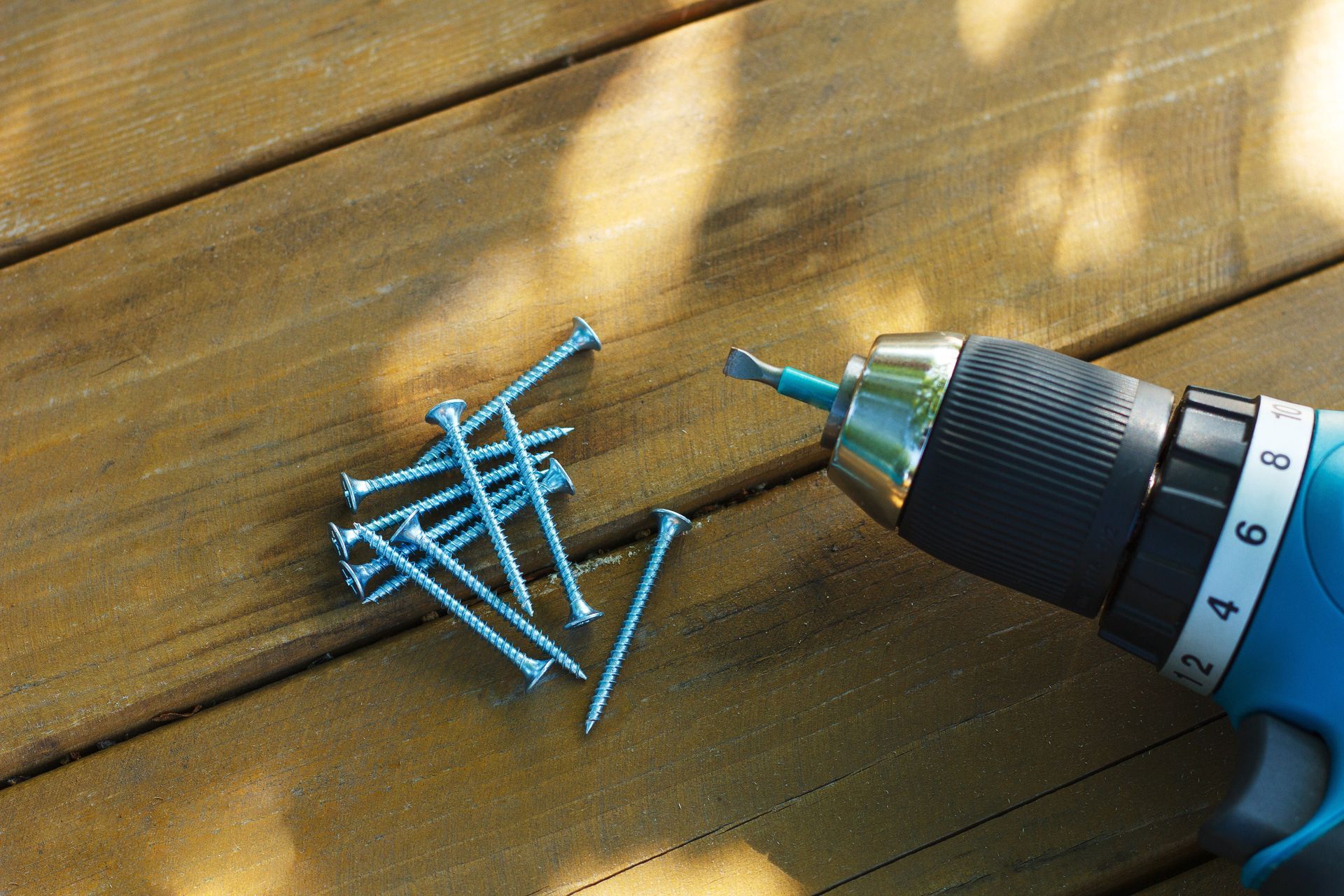Self-tapping screw and screwdriver on a wooden board. Self-tapping screw and screwdriver on a wooden board.