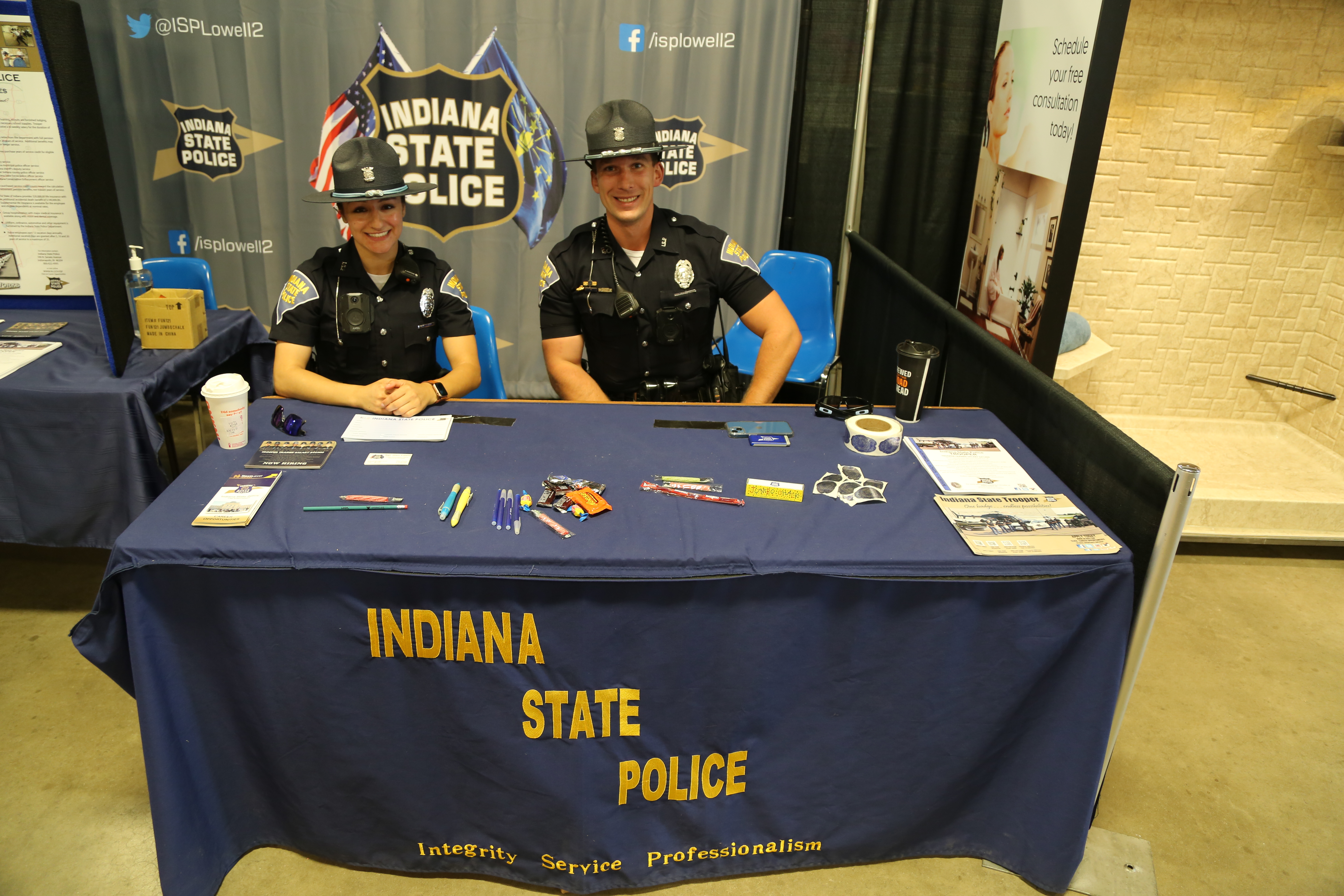 Fair booth with people, numbers 1-3, a tractor, and a sign that says