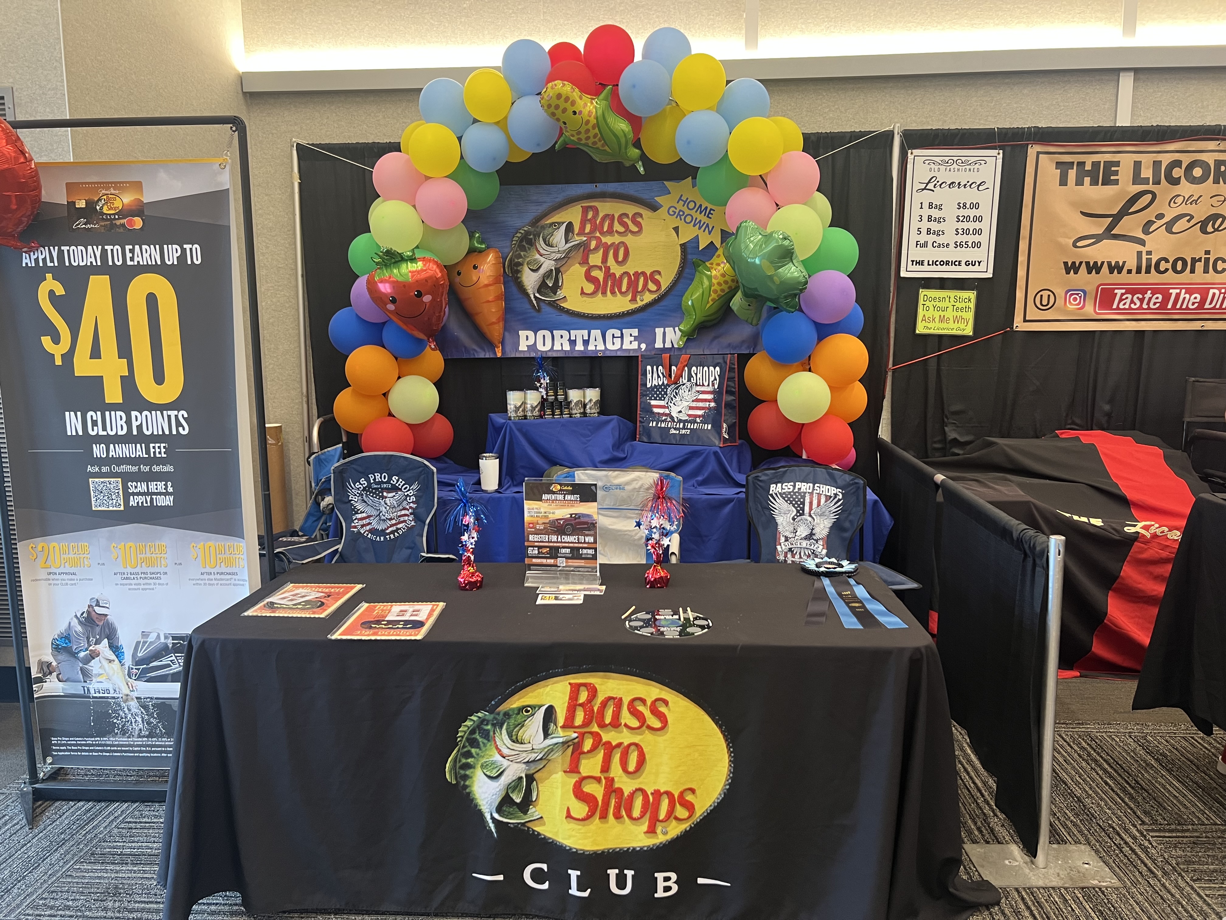 Hand holding a pretzel in front of a fair. White bag reads “Have a Pretzel Day!” Ferris wheel and booths in the background.