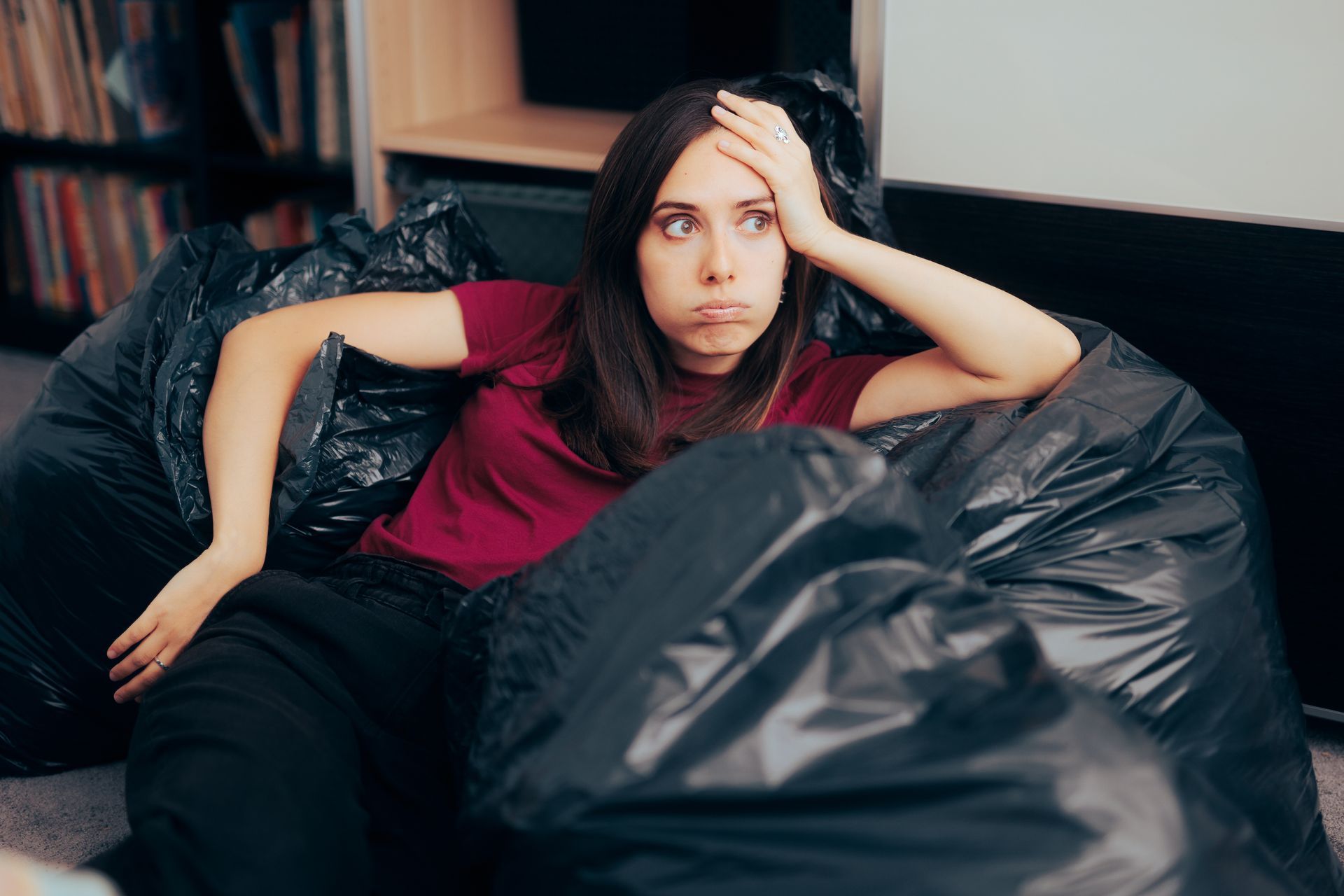 Woman decluttering Woman leaning on waste bags looking overwhelmed | Self Storage in Thurrock
