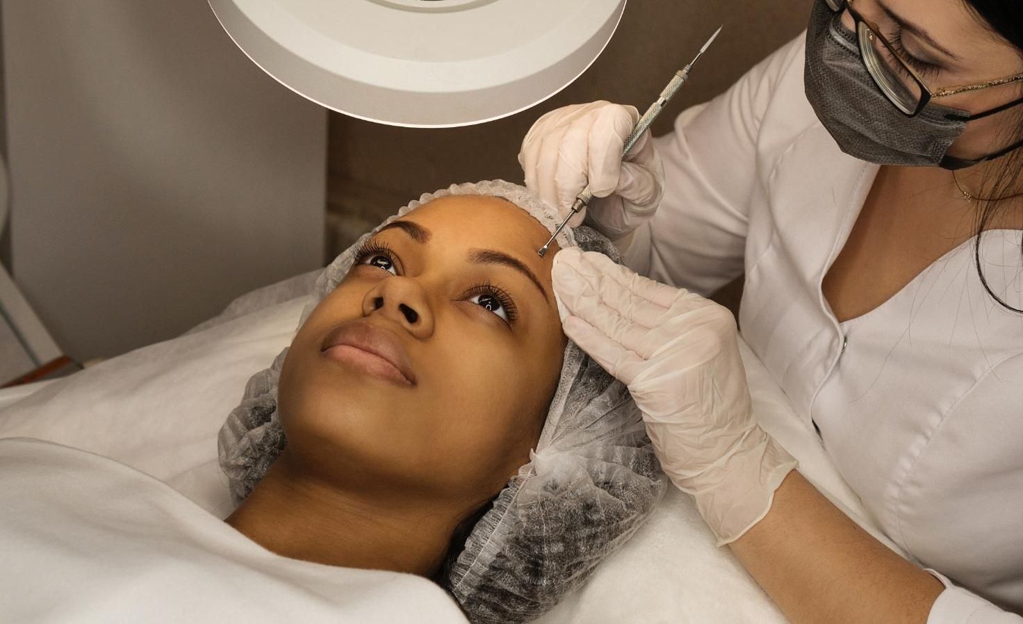 A woman is getting an acne facial treatment with extractions at a medspa