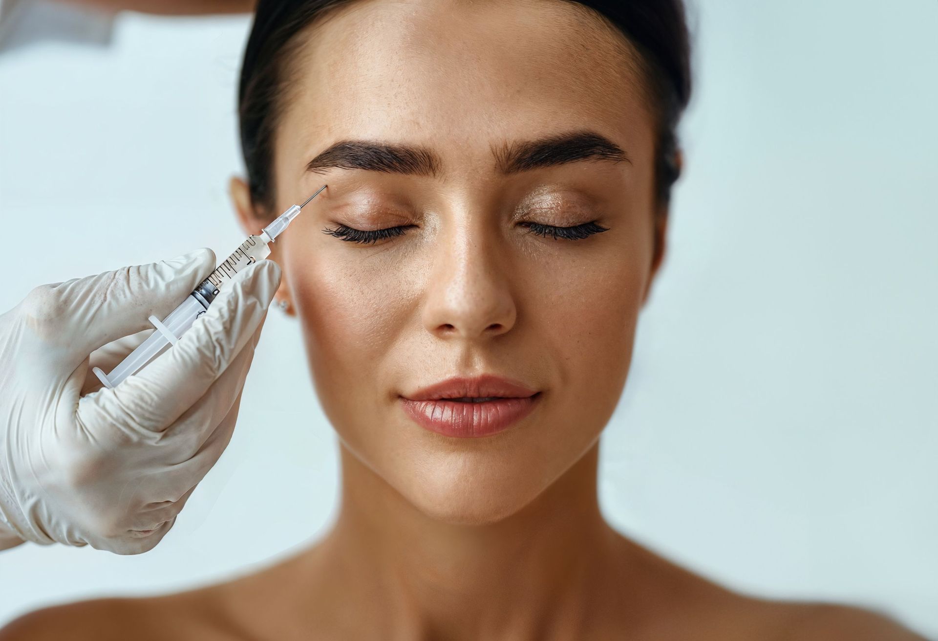 A woman is getting a botox injection in her eye.