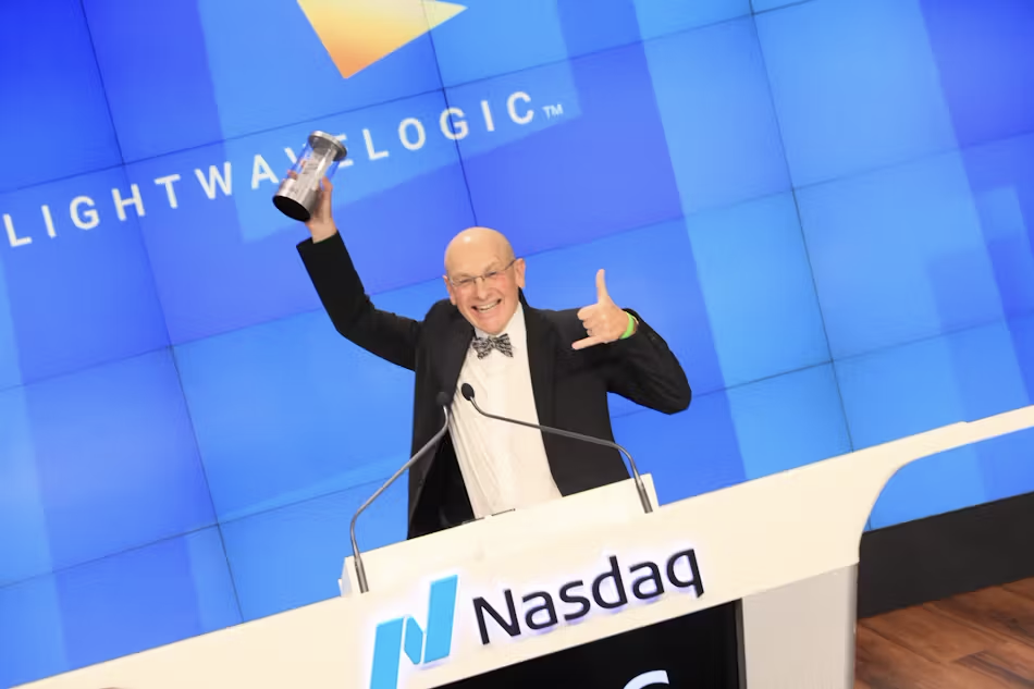 A man is giving a speech at a podium that says nasdaq