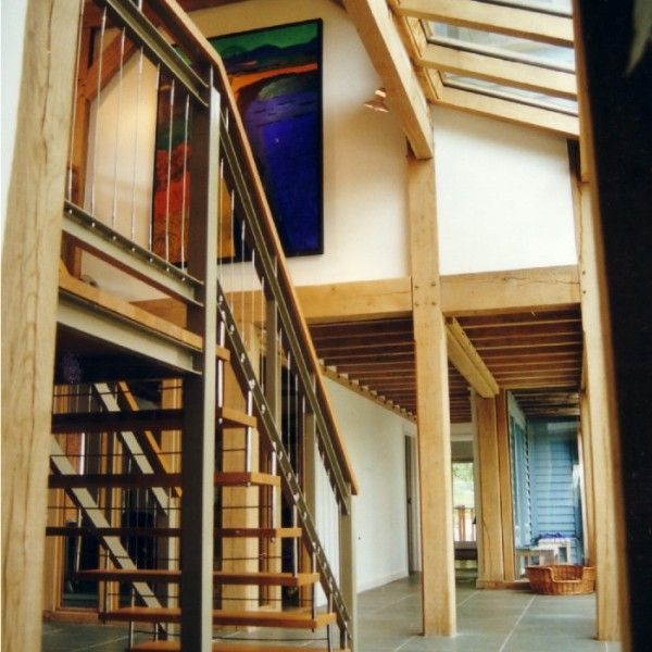 Modern interior with wooden beams, staircase, and mezzanine landing in a loft-style room