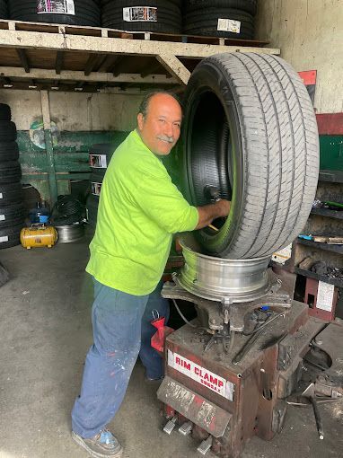 A man is working on a tire in a tire shop.