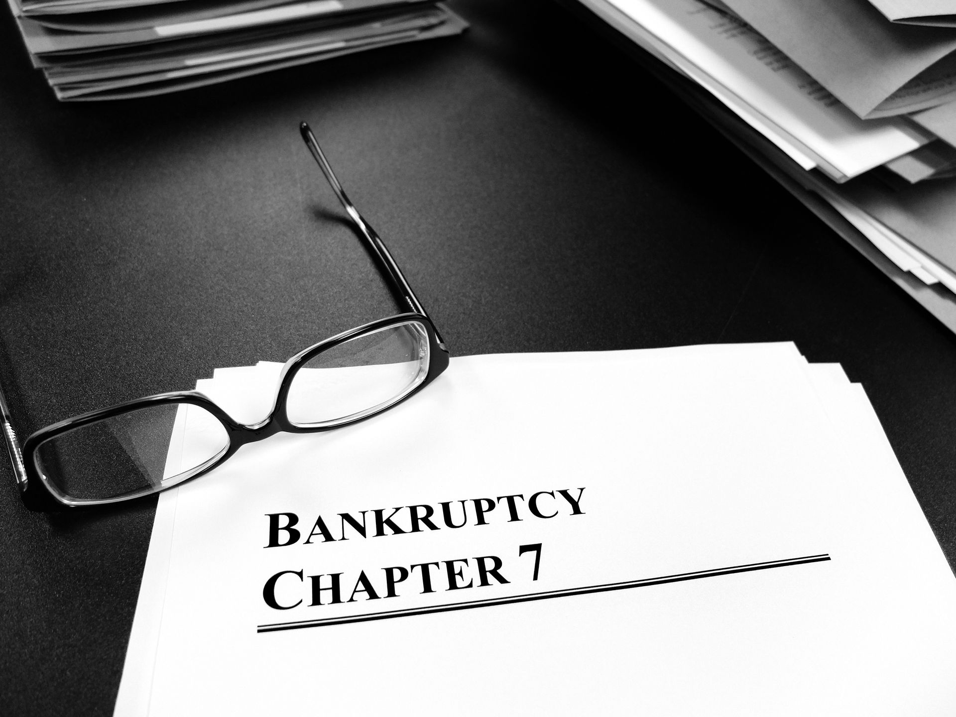Chapter 7 bankruptcy documents on desk with glasses showcasing the consultation of a trusted attorne