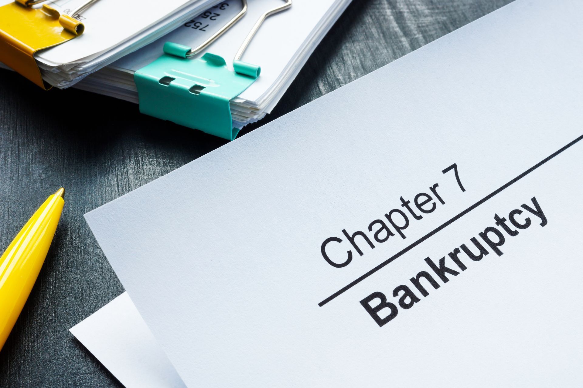 Documents about Chapter 7 bankruptcy and yellow pen.