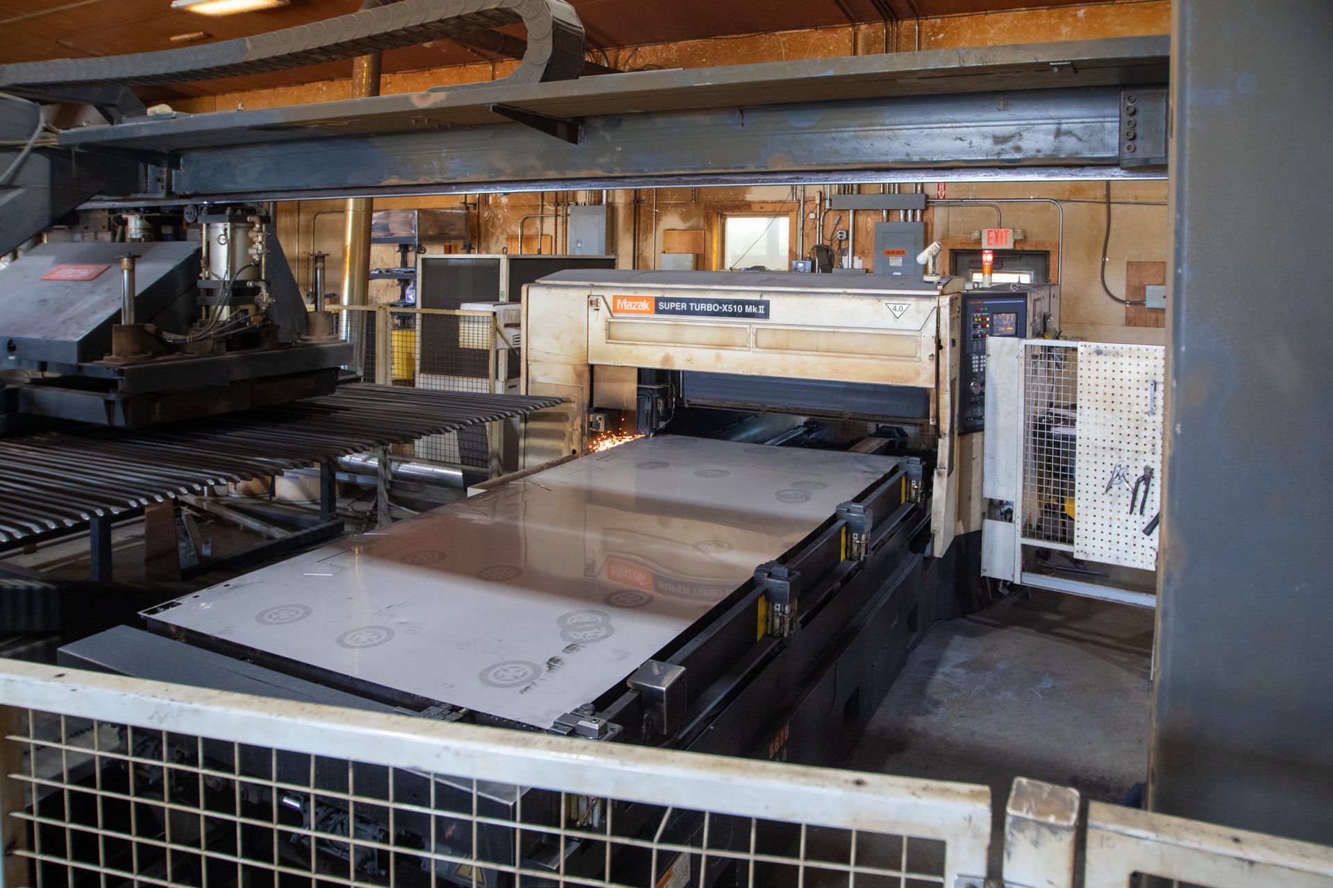 Large industrial laser cutting machine with metal sheet being cut.