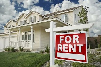 Suburban house with a red “For Rent” sign in the front yard