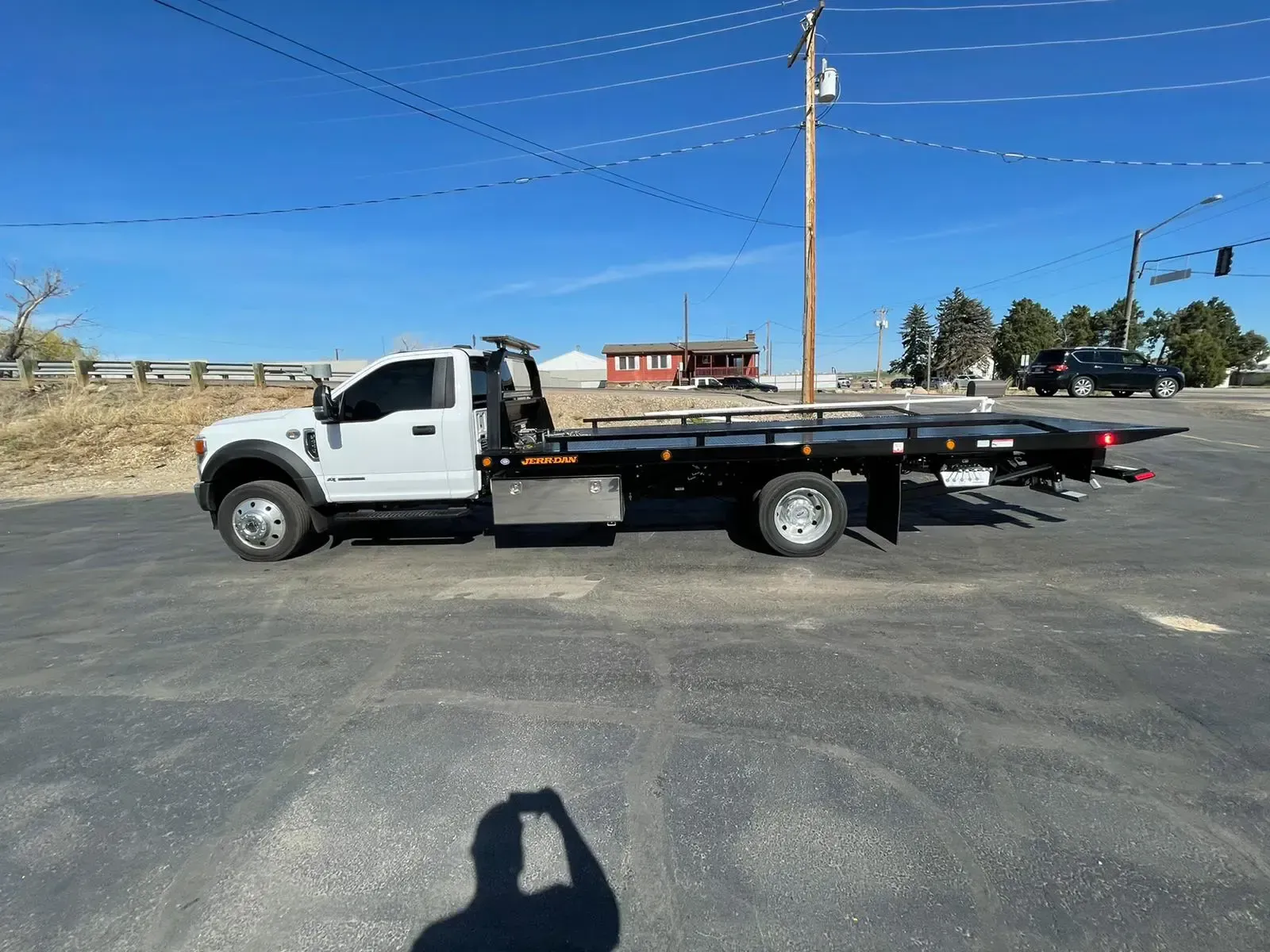A white tow truck is parked on the side of the road.