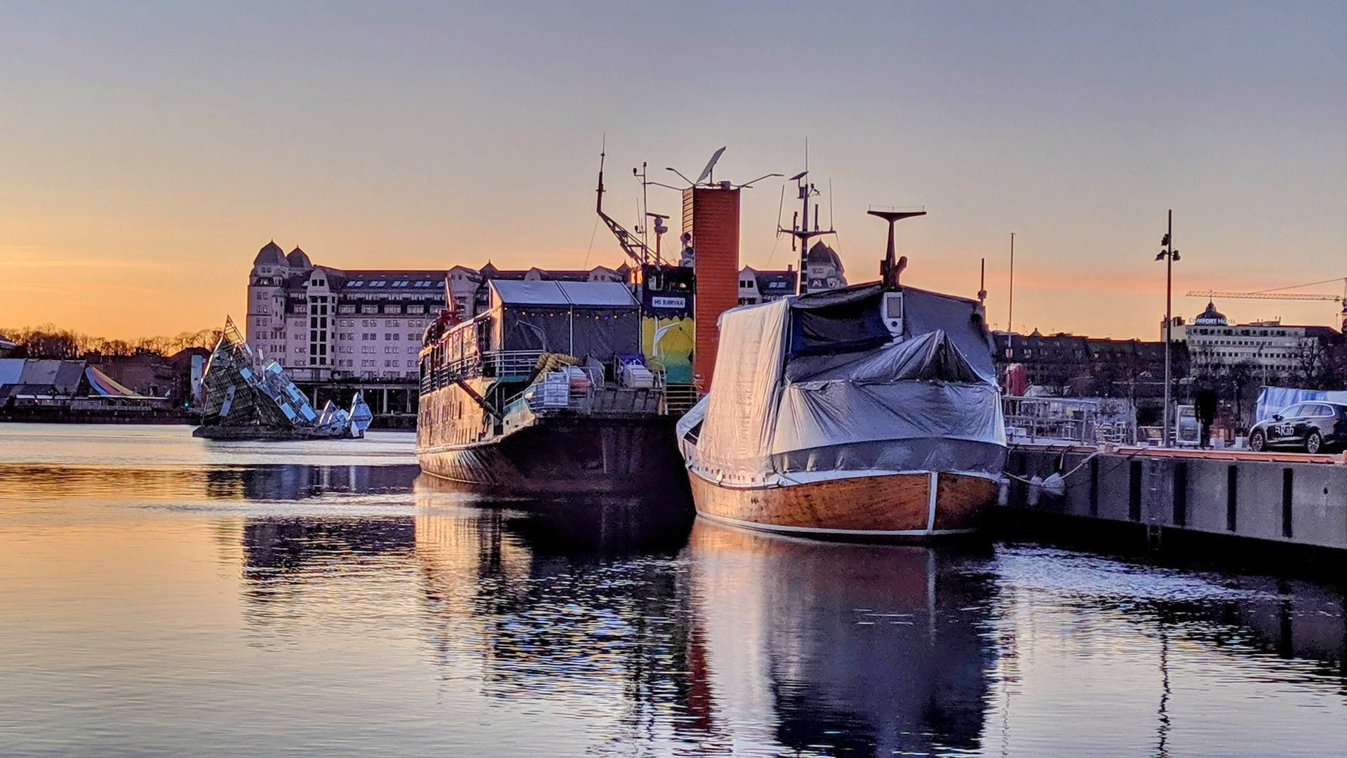 The group of ship docked in Oslo harbour (Oslobukta) upon evening glow and water reflections