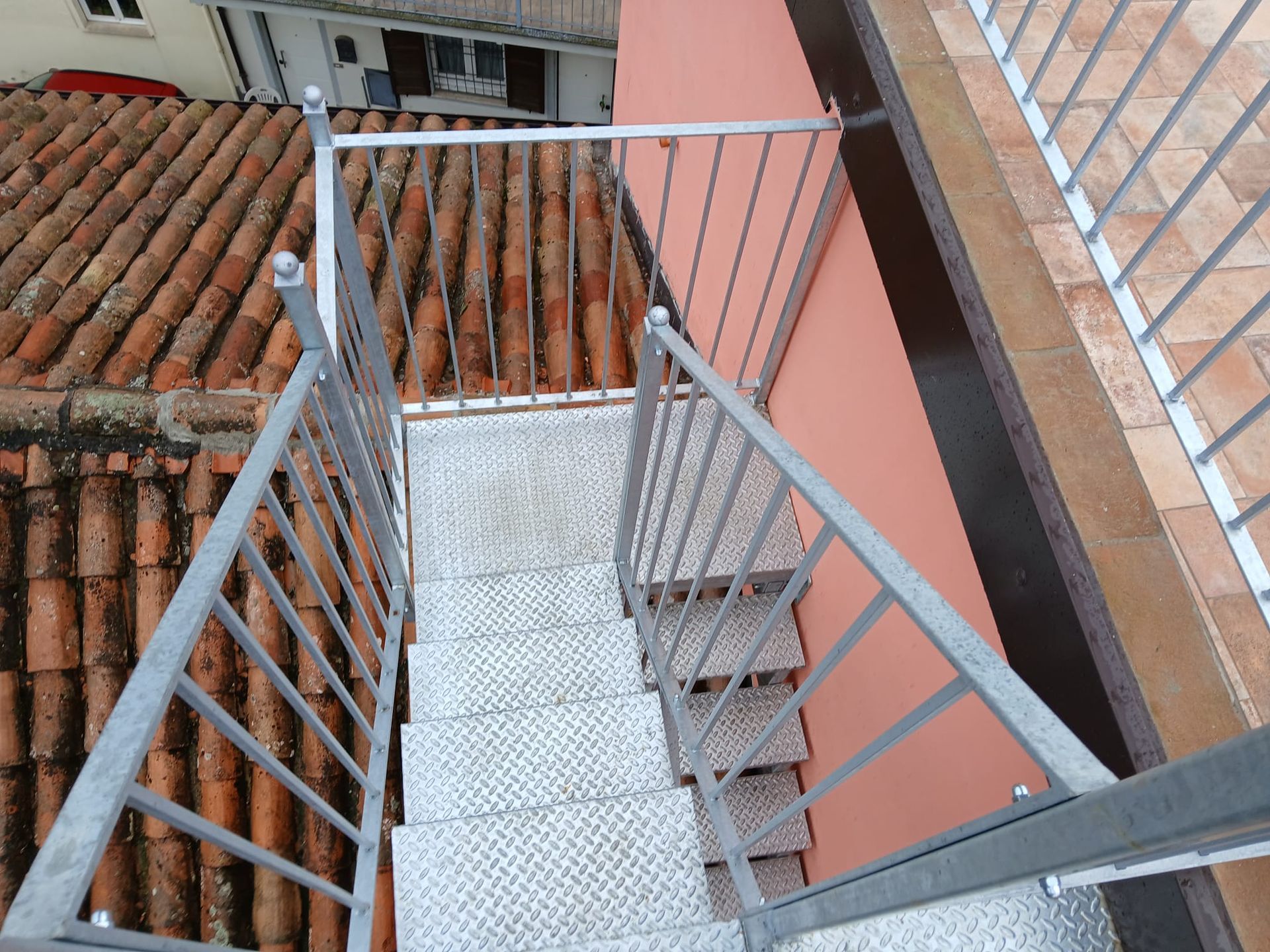 L'interno di uno showroom che espone vari telai per finestre e porte realizzati con materiali bianchi e marroni su un pavimento effetto legno.