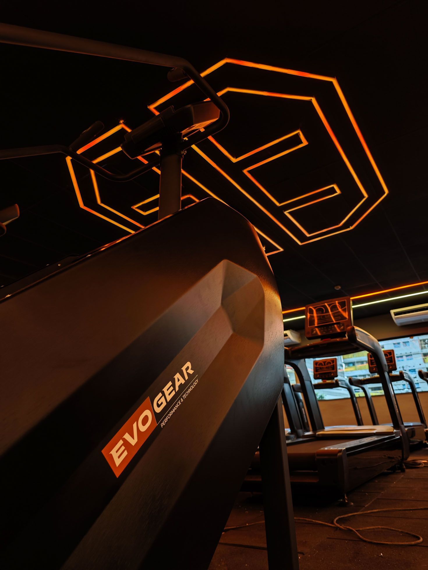 Uma esteira em uma academia evogear com um logotipo da evo gear no teto.
