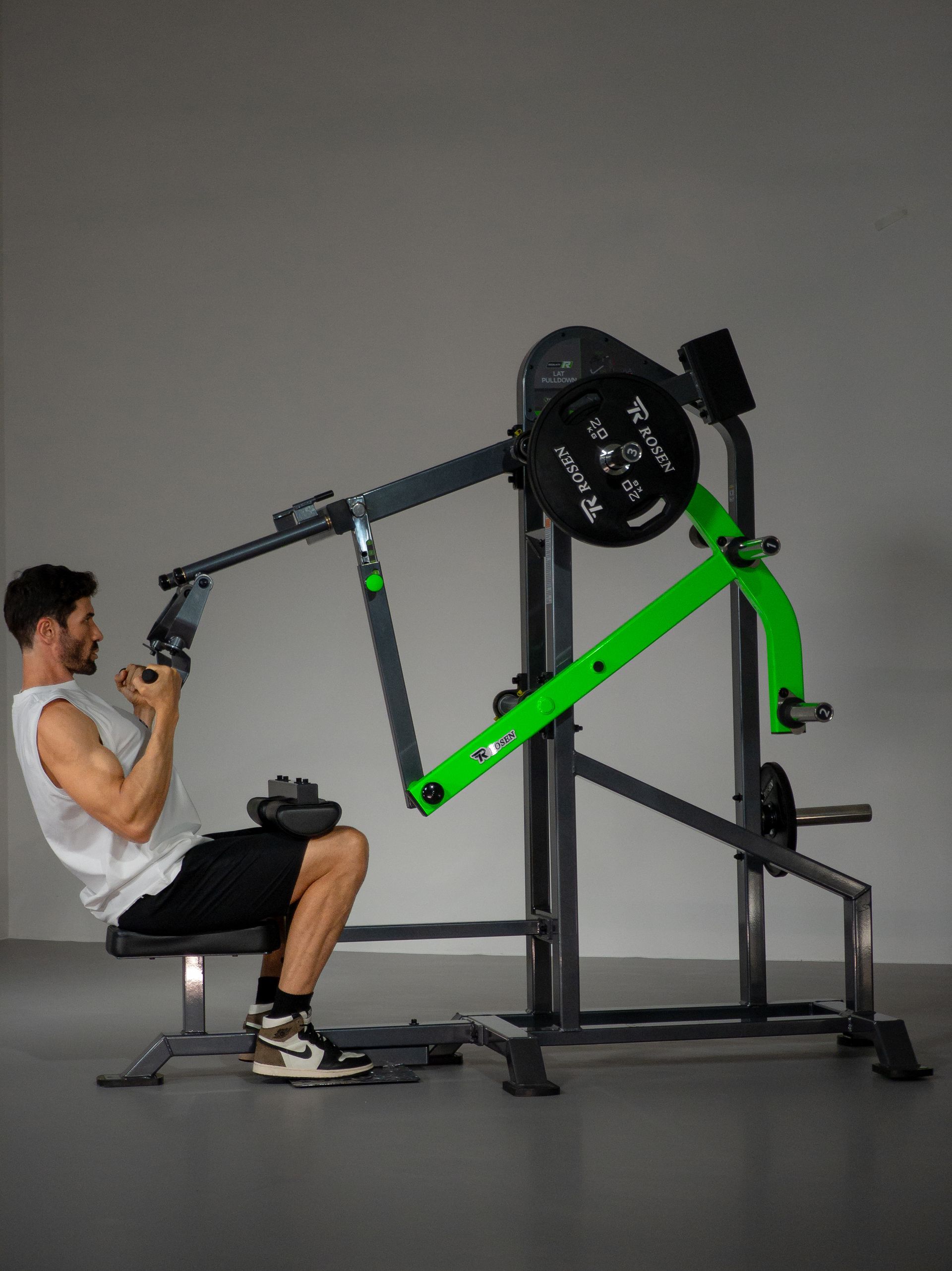 Homem usando uma máquina de supino sentado em uma academia, levantando barras verde-limão.