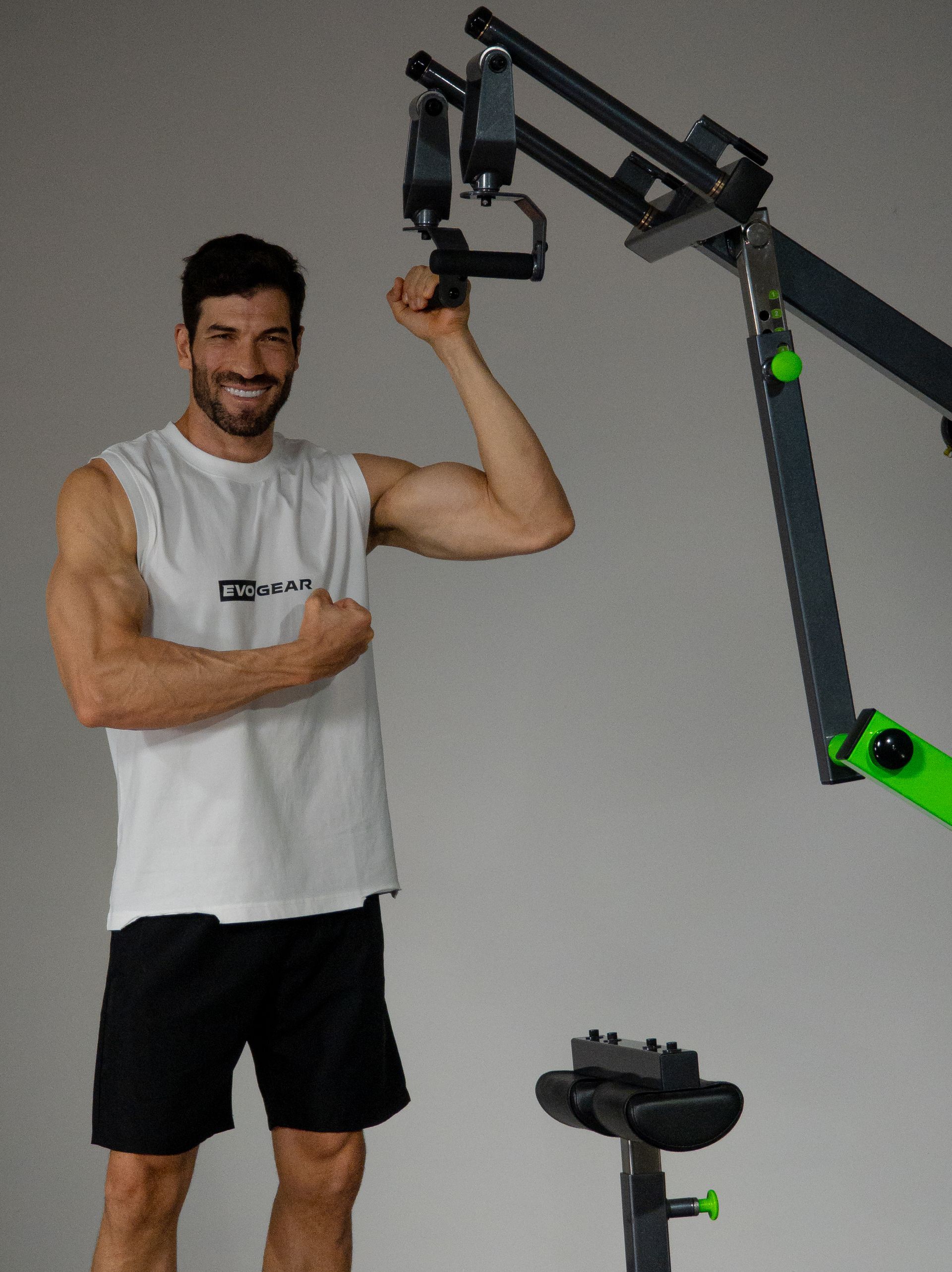 Homem posando ao lado de um aparelho de exercícios 