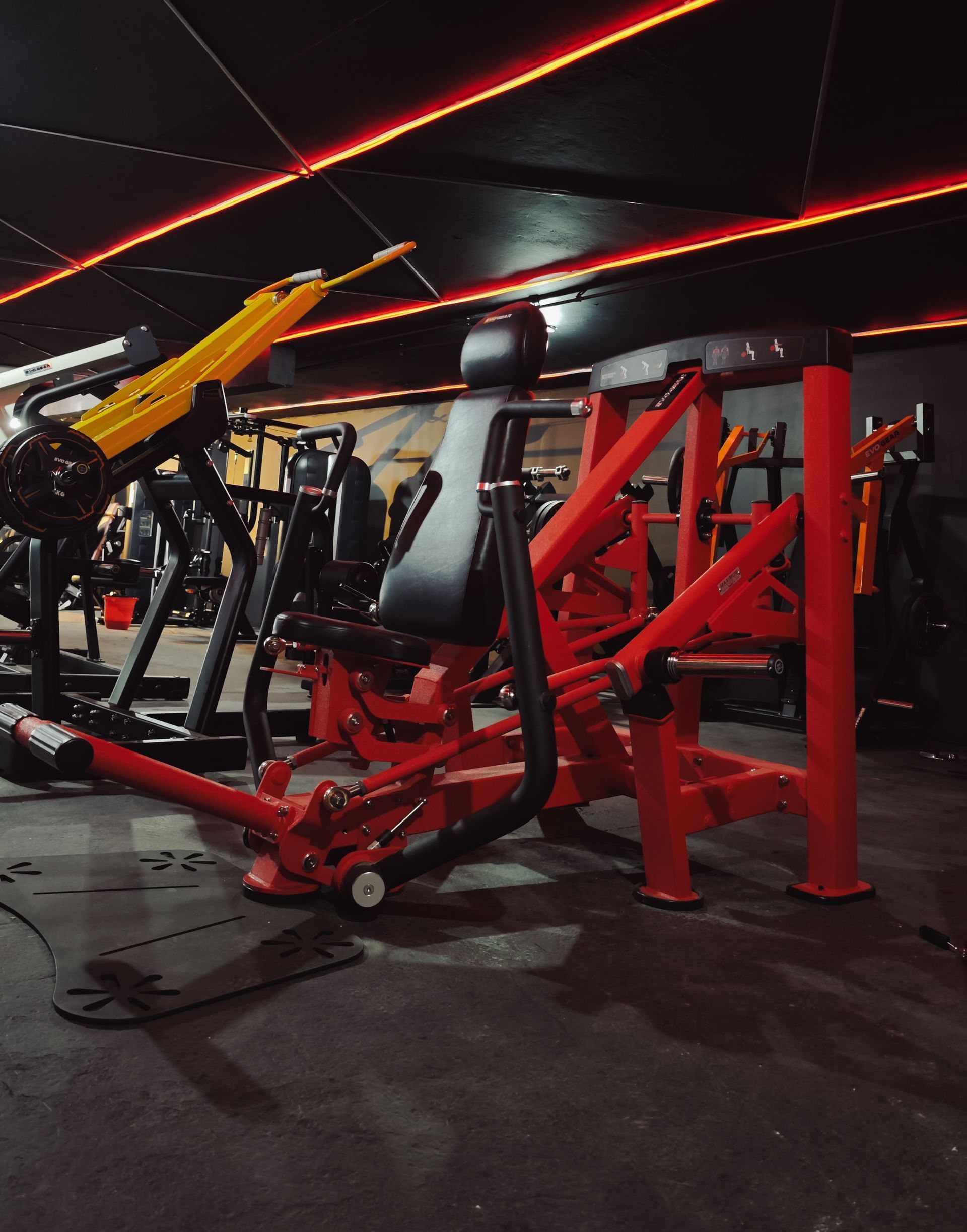 Uma academia com muitos equipamentos de exercícios vermelhos e amarelos