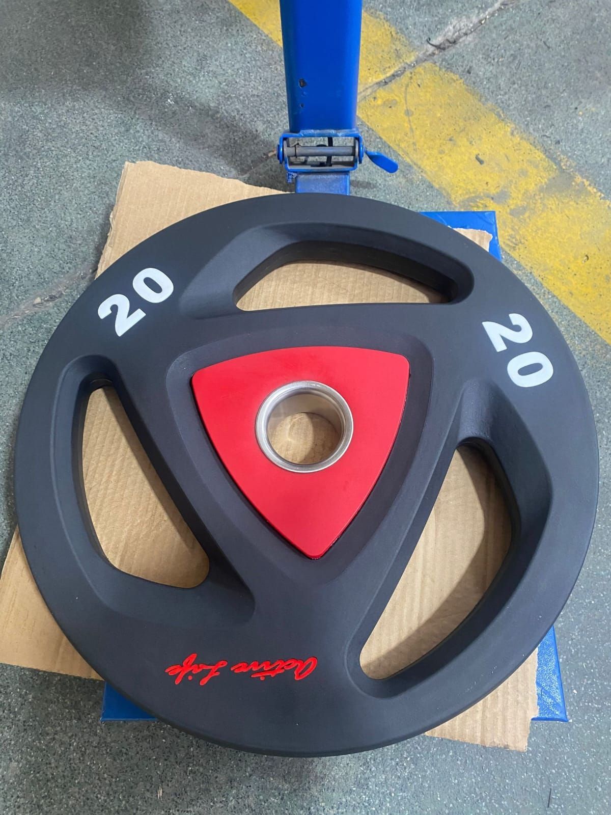 Uma placa de peso preta e vermelha com o número 20