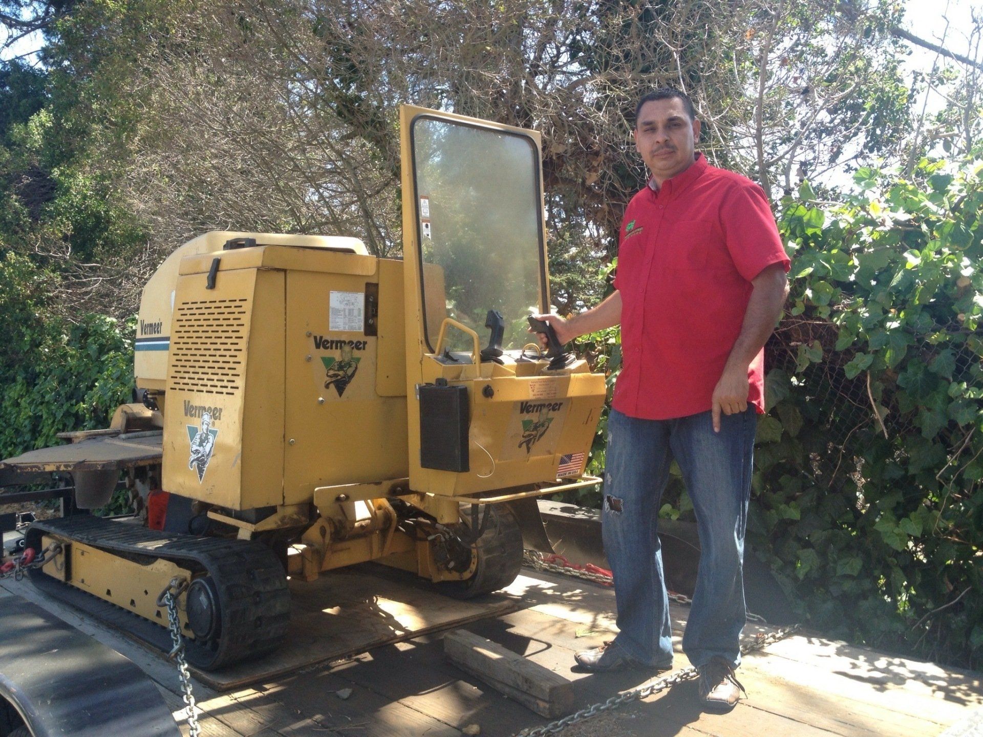 Timberland Tree Care owner-Albert Briseno standing next to his stump grinder machine