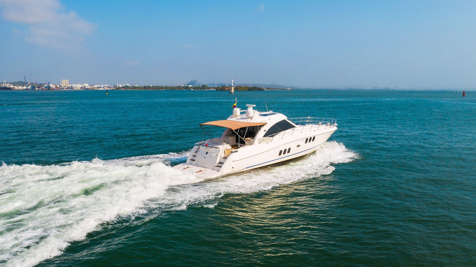 A white yacht is floating on top of a large body of water.