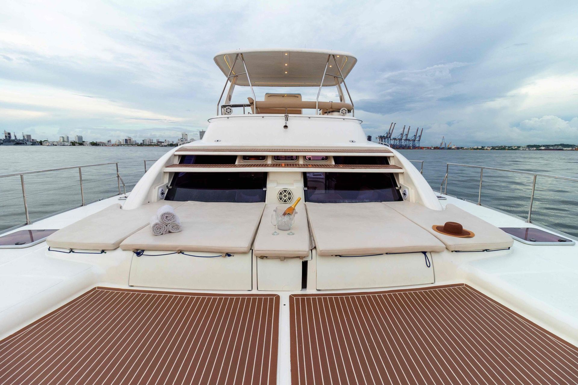 The front of a white yacht with a wooden deck