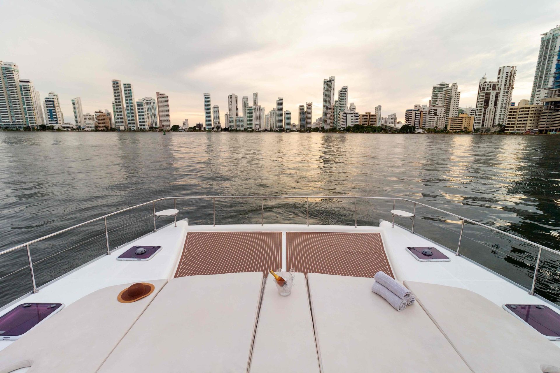 A boat is floating on top of a body of water with a city skyline in the background.