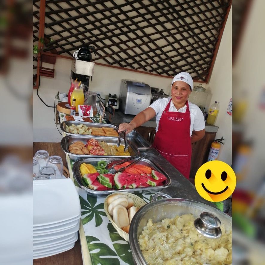 A woman in a red apron is preparing food on a table