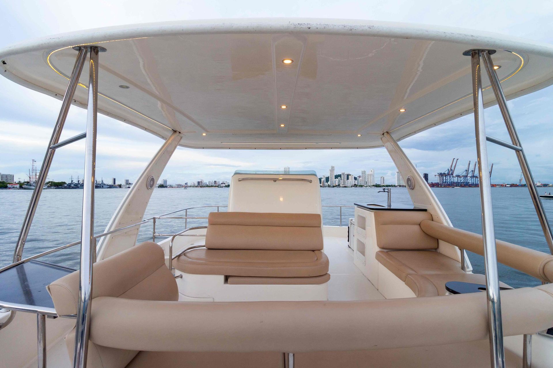 The front of a boat with a canopy over it is sitting in the water.