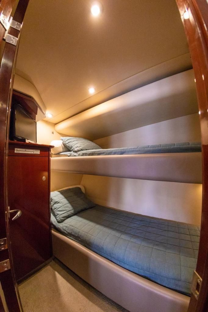 There are two bunk beds in this room on a boat.