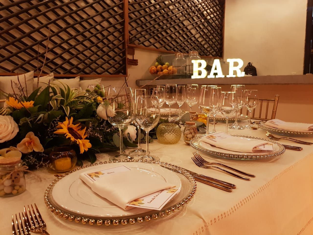 A table with plates and utensils and a sign that says bar