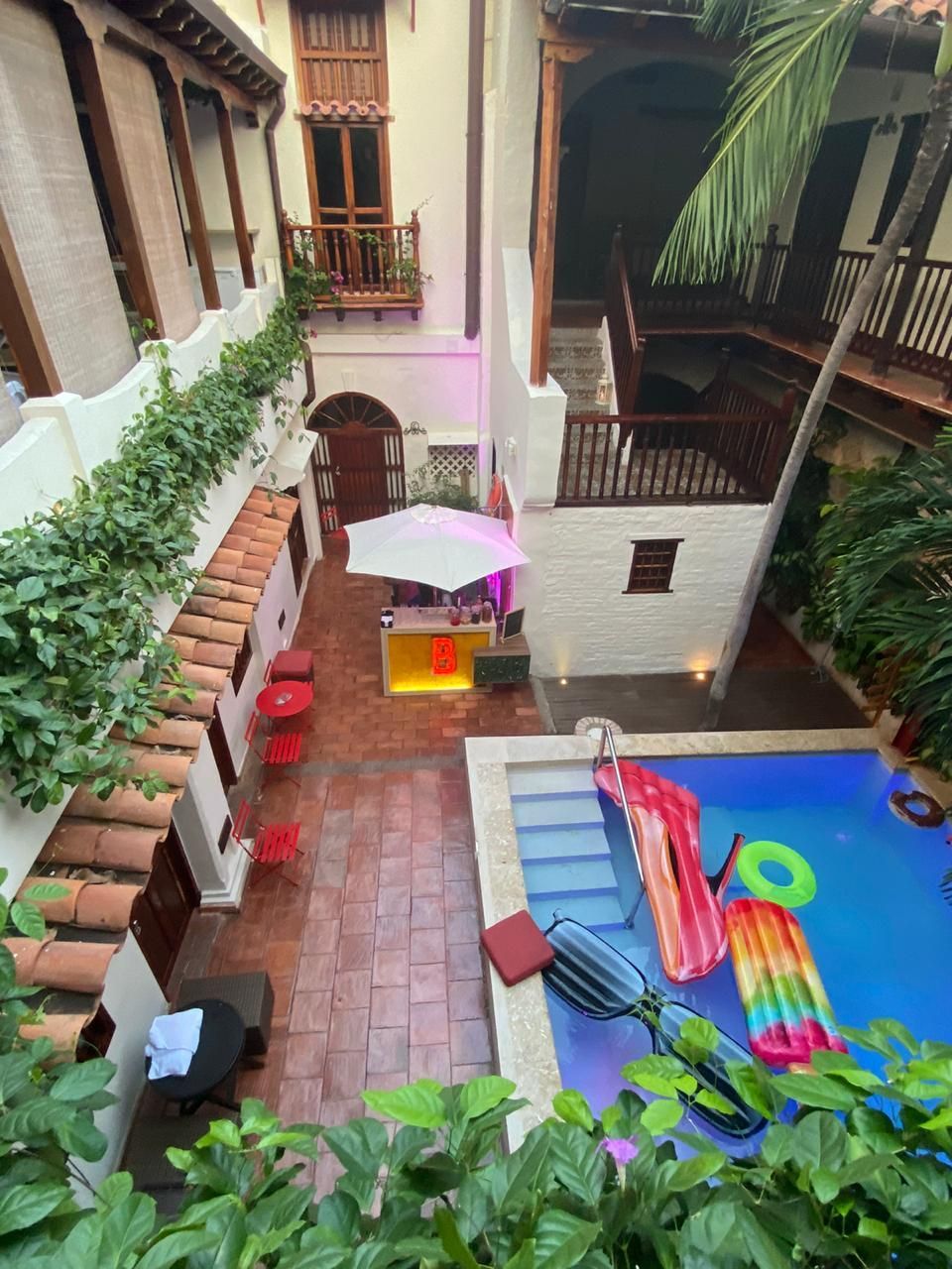 An aerial view of a swimming pool in the middle of a courtyard.