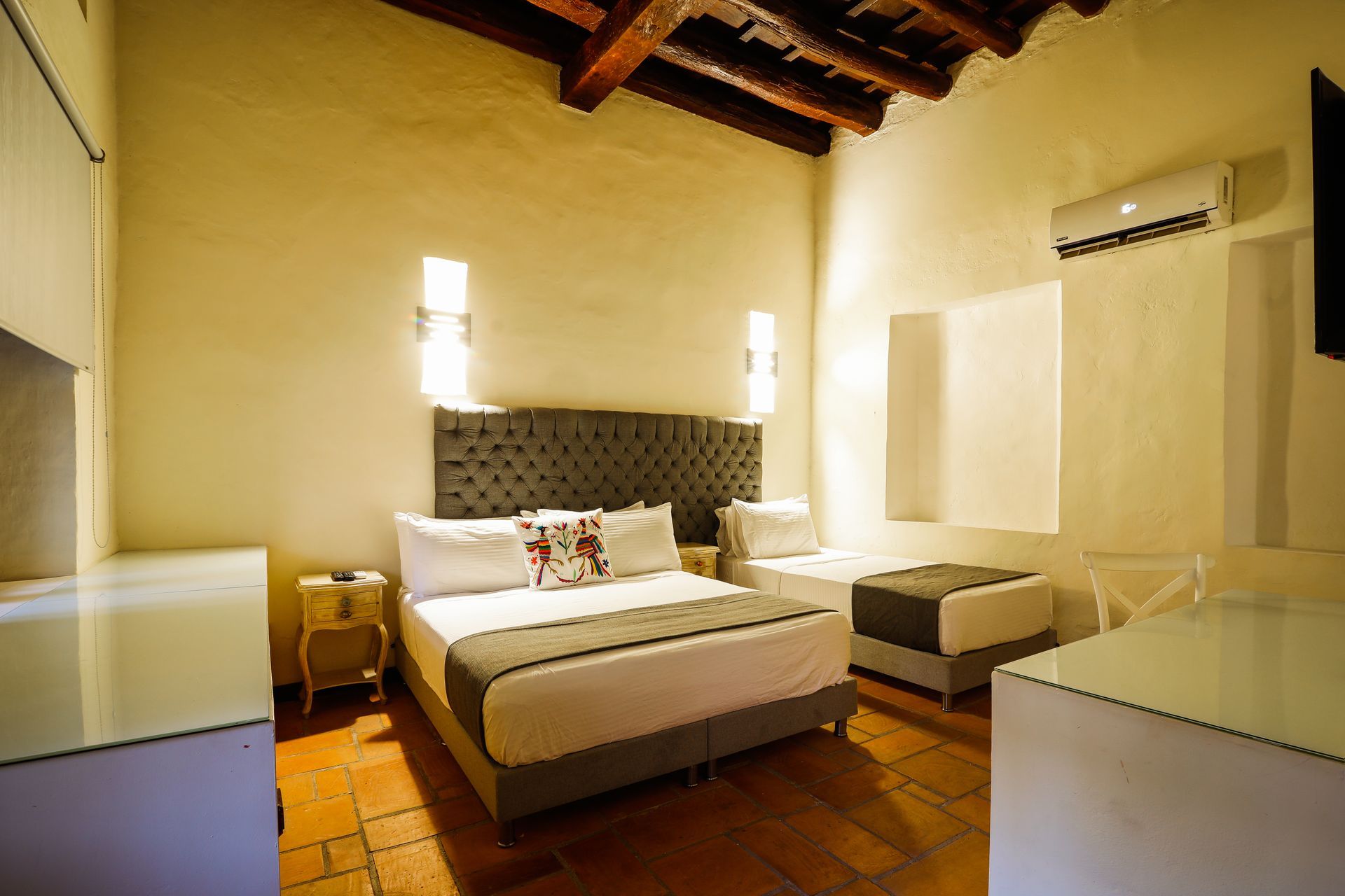 A hotel room with a king size bed and two twin beds.