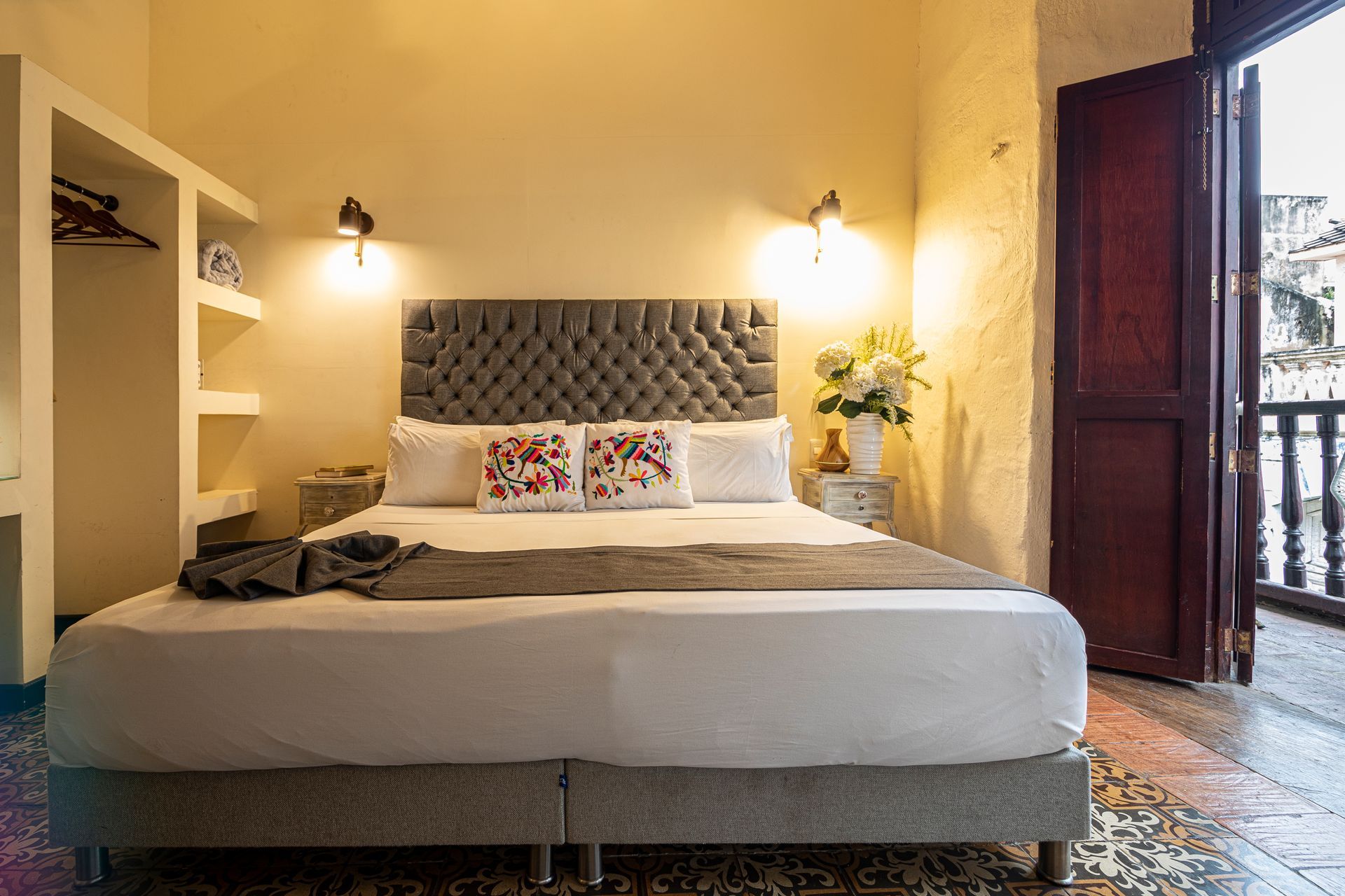 A bedroom with a large bed and a balcony.