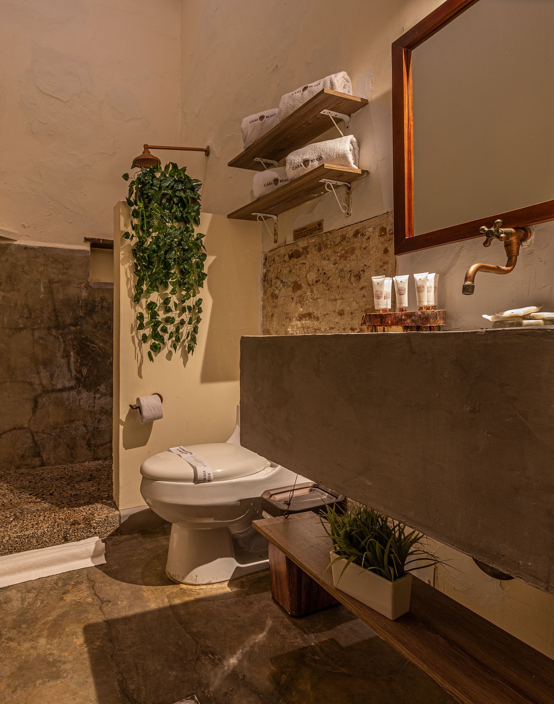 A bathroom with a toilet , sink and mirror.
