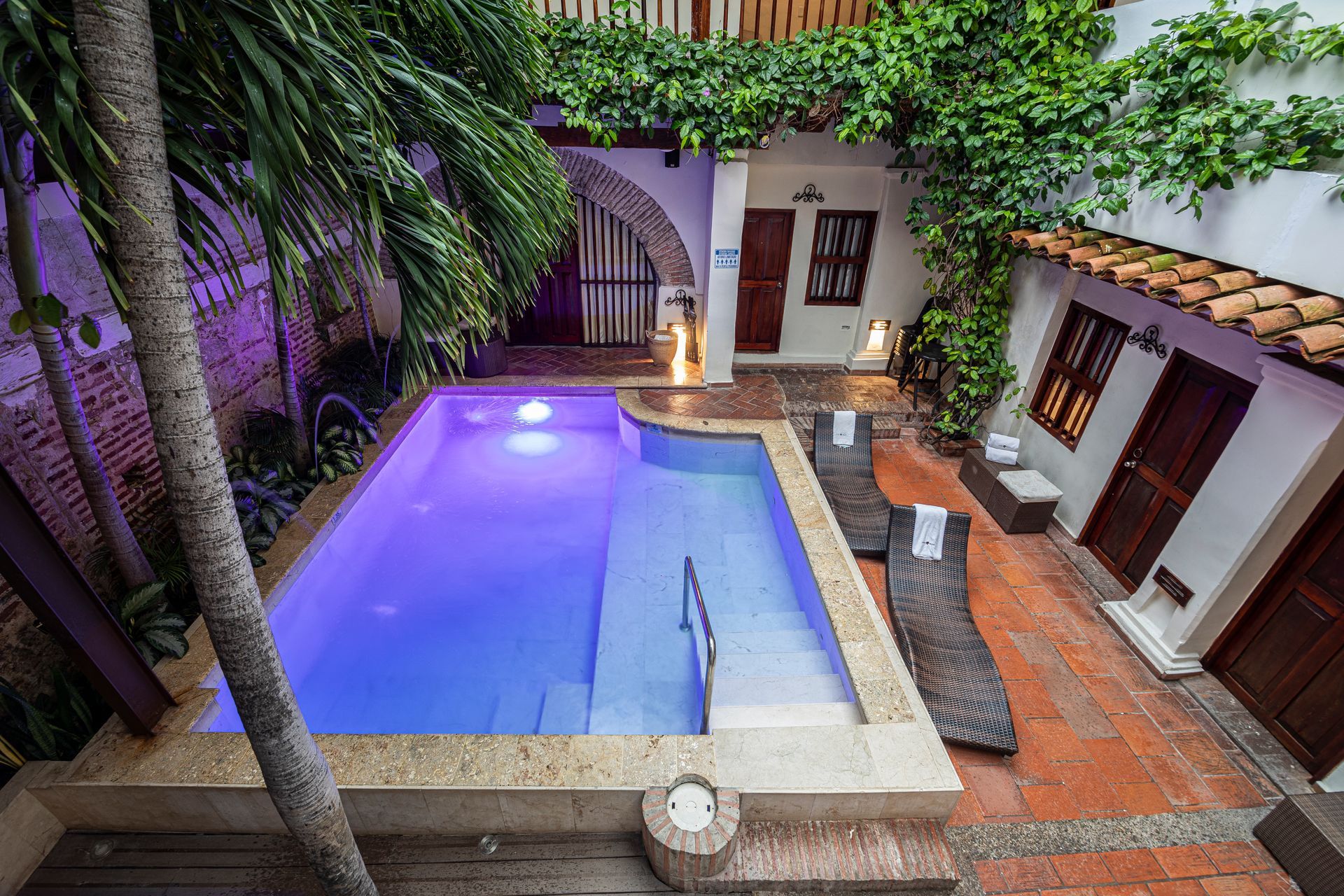 There is a large swimming pool in the backyard of a house.