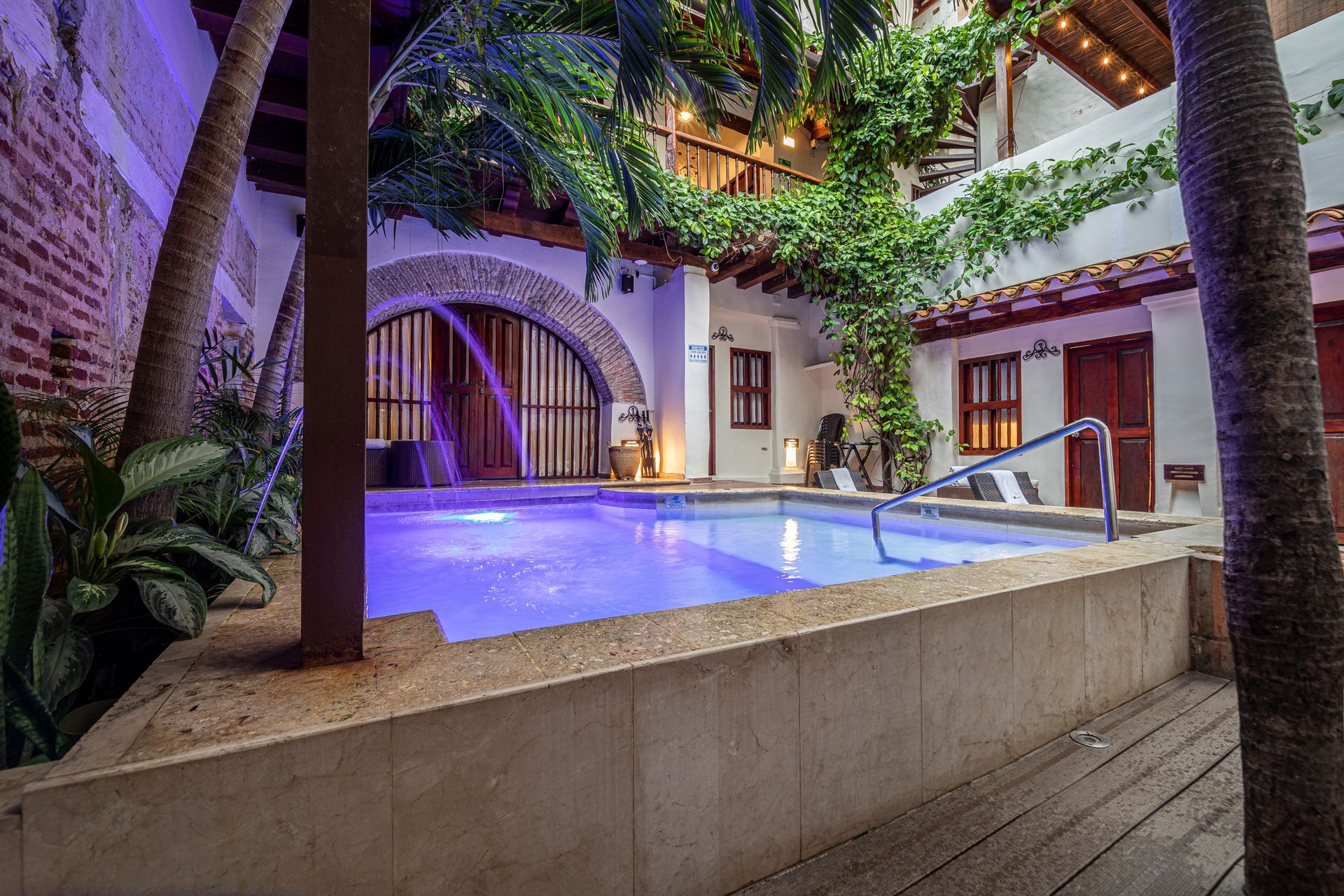 There is a large swimming pool in the middle of a courtyard.