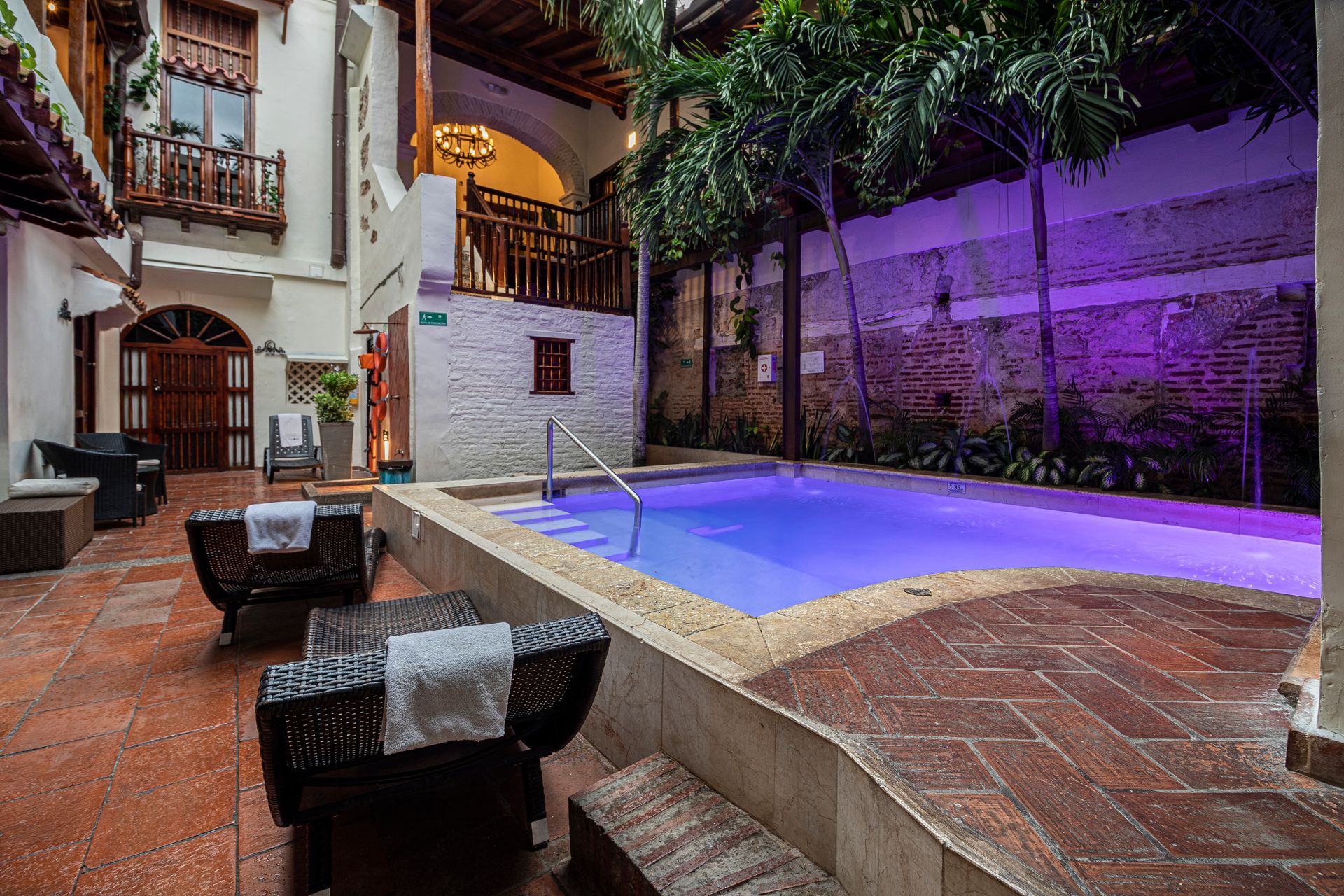 There is a large swimming pool in the middle of a courtyard.