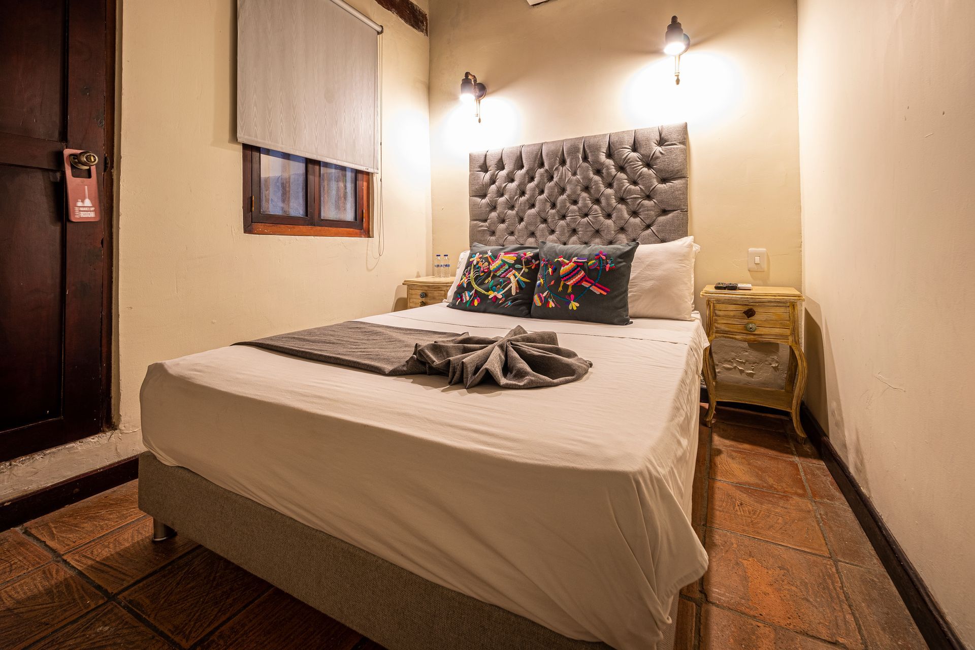 A bedroom with a bed , nightstands , and a window.