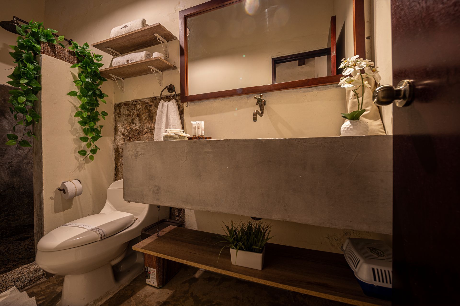 A bathroom with a toilet , sink and mirror.