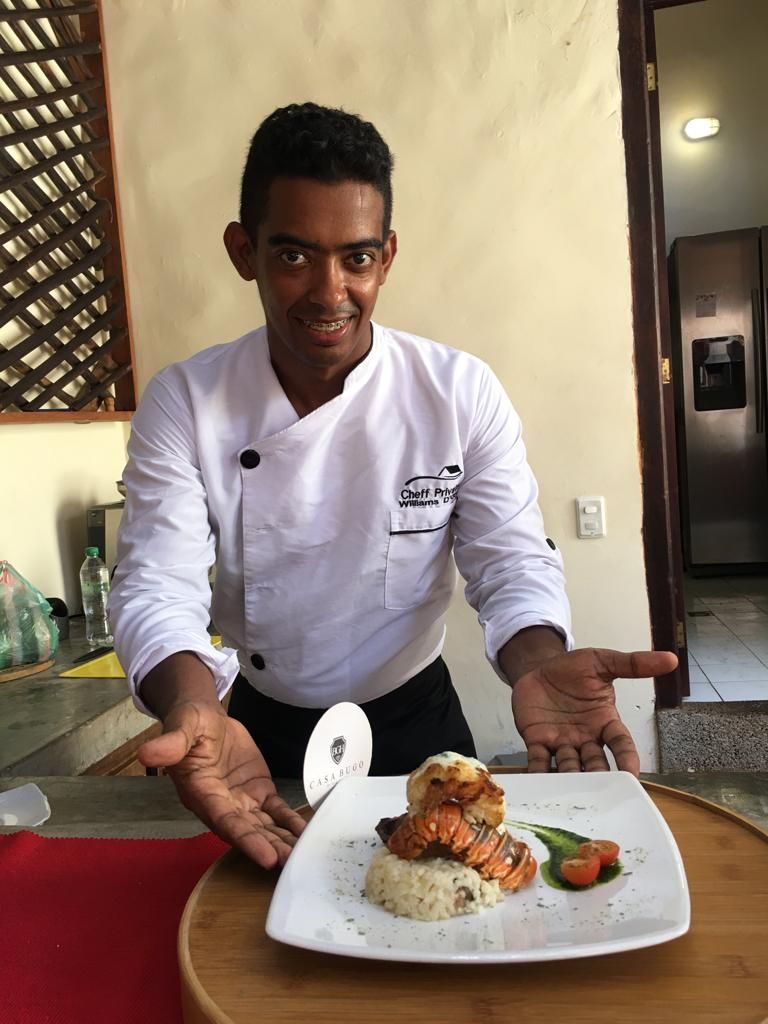 A chef is holding a plate of food in his hands.