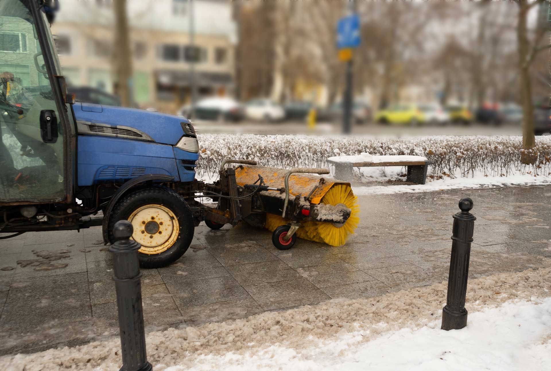 Blue street sweeper clearing snow from a sidewalk. Blue street sweeper clearing snow from a sidewalk.