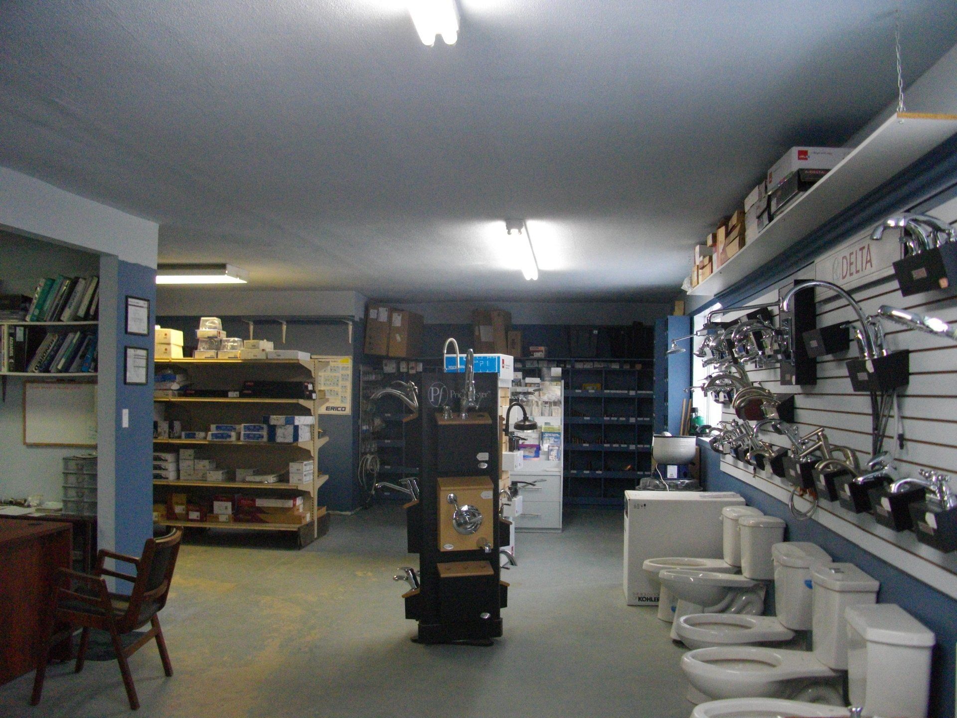 Intérieur d'une quincaillerie présentant des articles et fournitures de plomberie.
